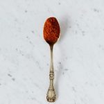 silver spoon with red paprika powder